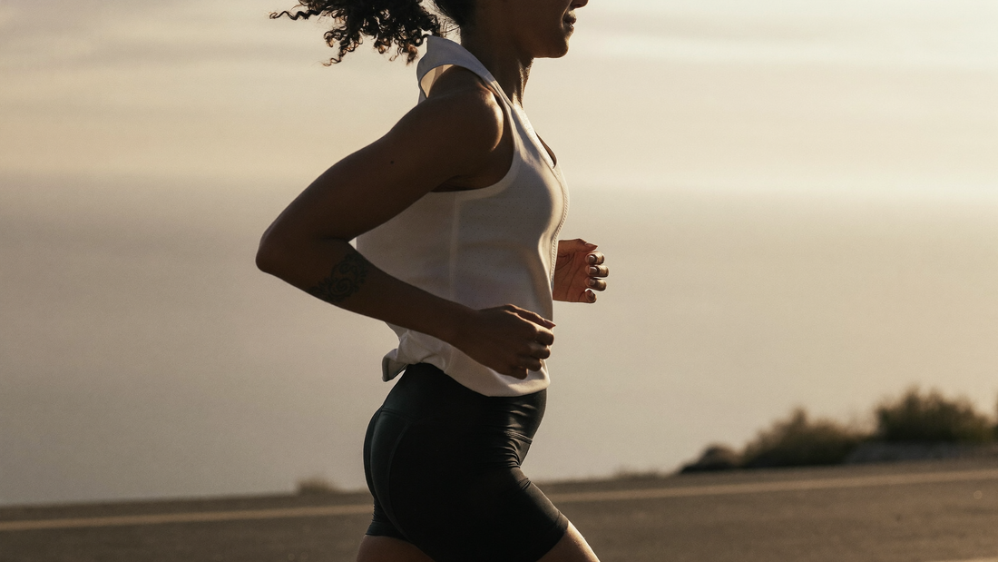Coureur en respiration nasale sur une route côtière au lever du soleil, bouche fermée, allure d'endurance en zone 2