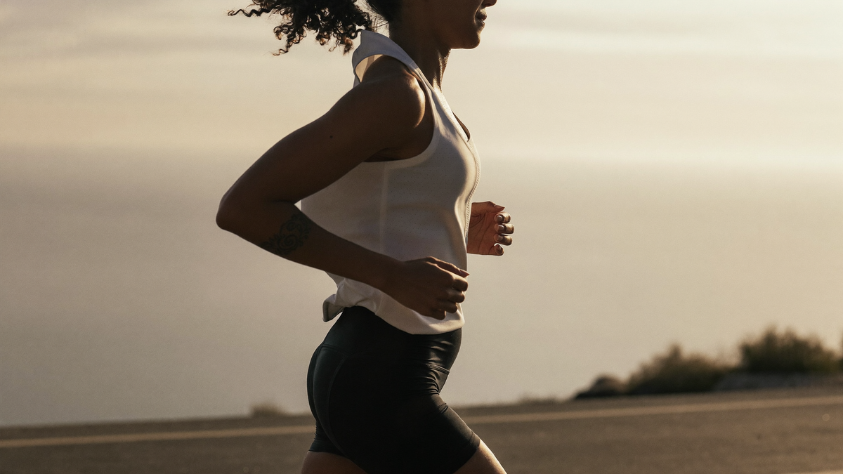 Coureur en respiration nasale sur une route côtière au lever du soleil, bouche fermée, allure d'endurance en zone 2